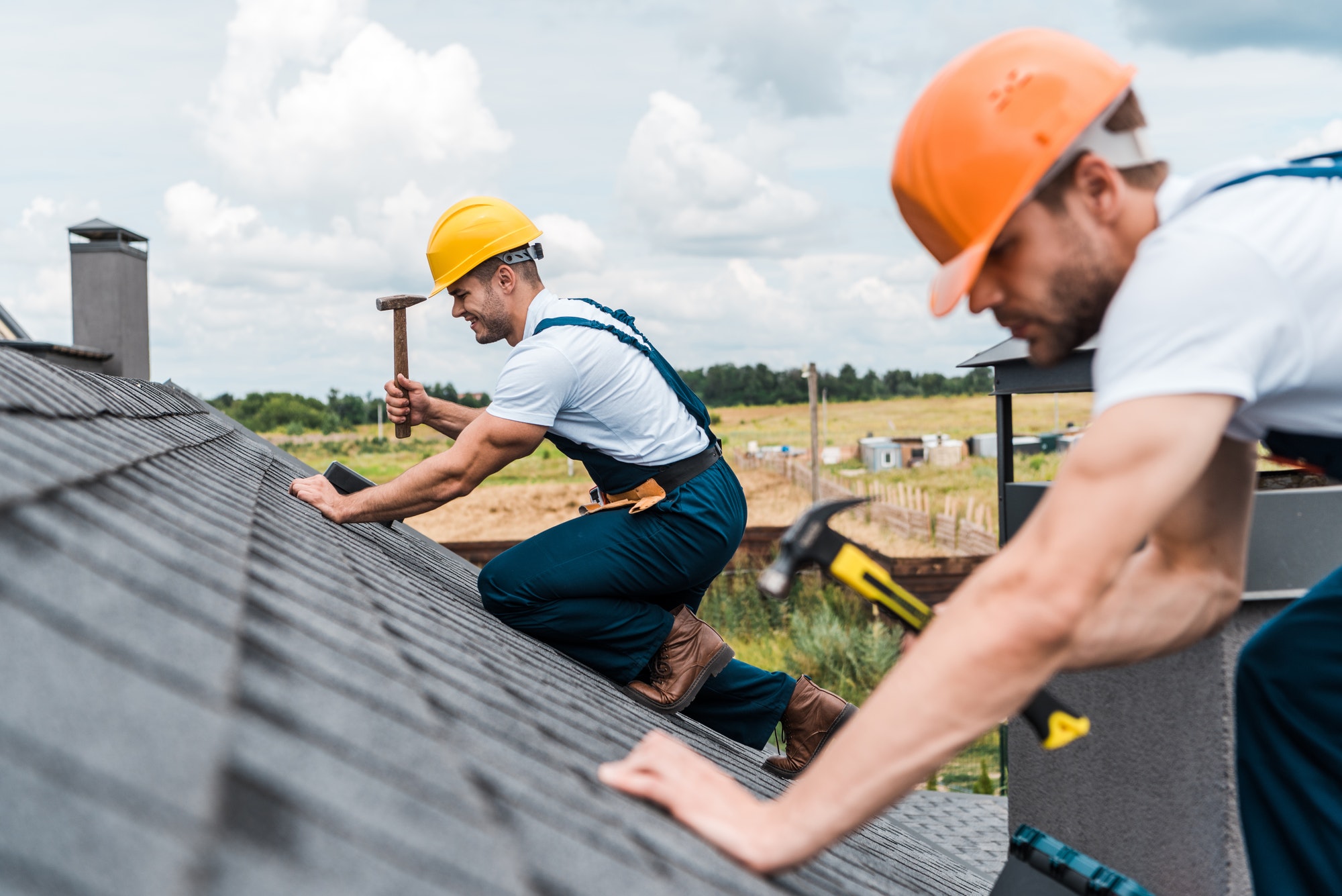 selective-focus-of-handsome-handyman-repairing-roof-with-colleague.jpg